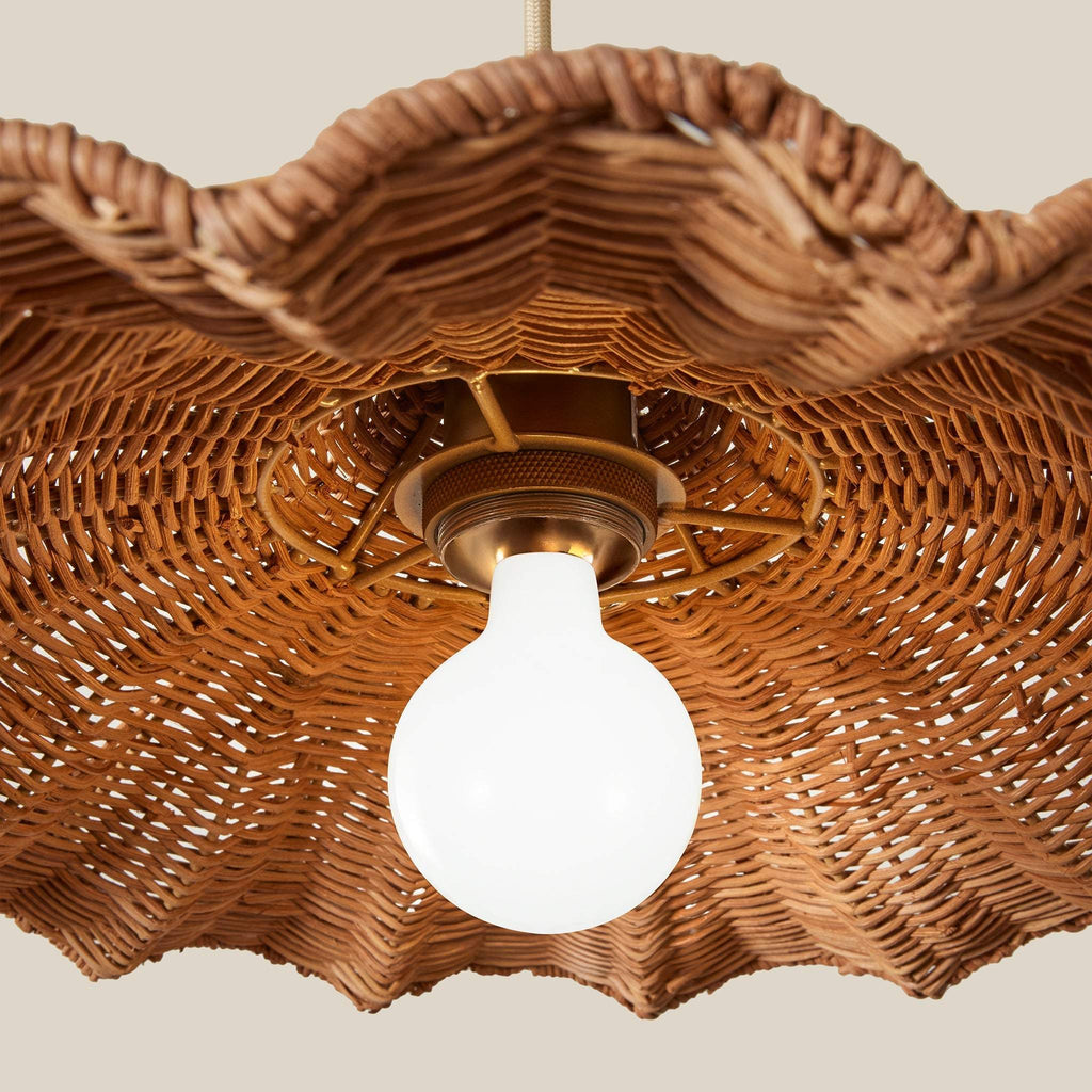 Savannah wicker lampshade with a light bulb inside on a neutral background