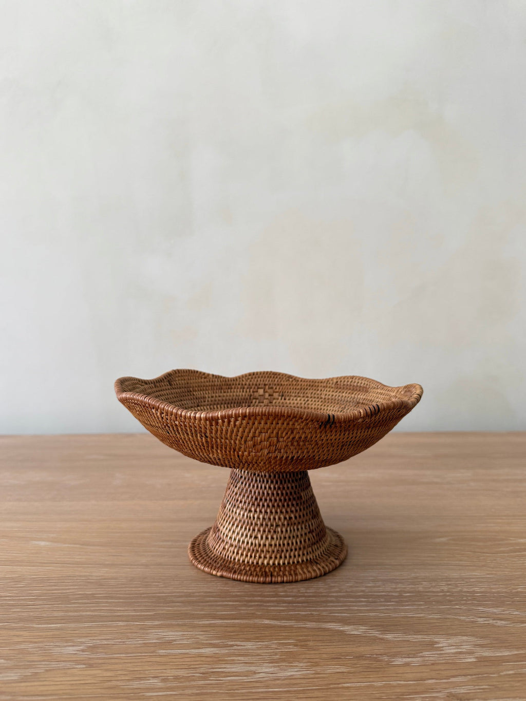Handwoven scalloped Tenganan bowl made from natural Ata reed with intricate weaving and pedestal base