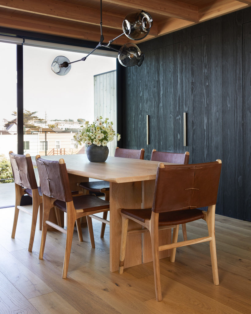 Sofia Dining Chairs in Saddle in a modern dining room with Shu Sugi Ban cabinets and oak table and floors. Angle view.