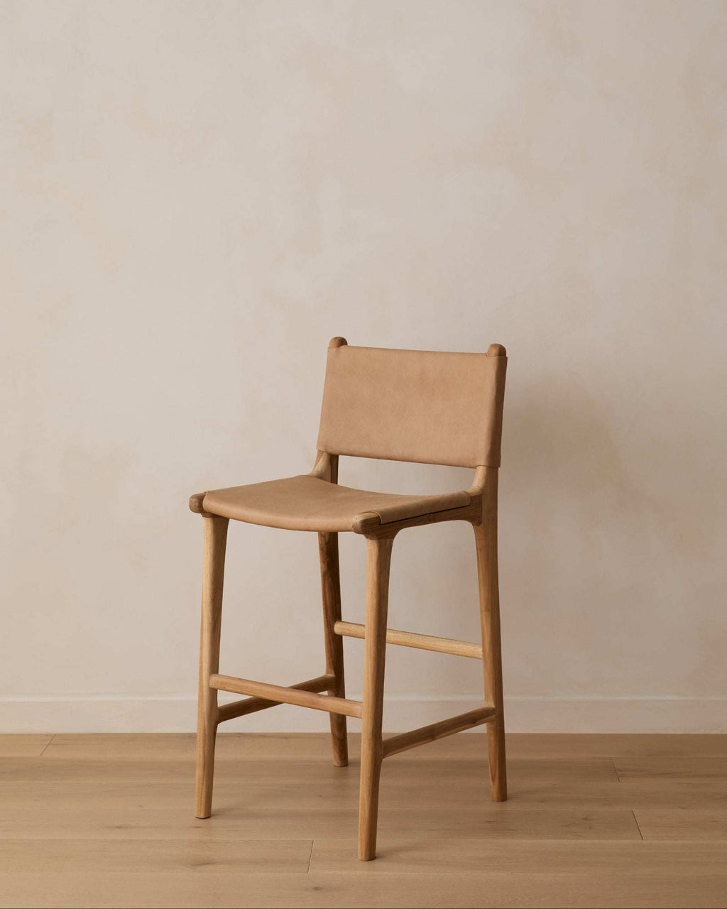 Beige Sofia Counter Stool with stretched leather and teak wood frame showcasing elegant leather ties and handcrafted design
