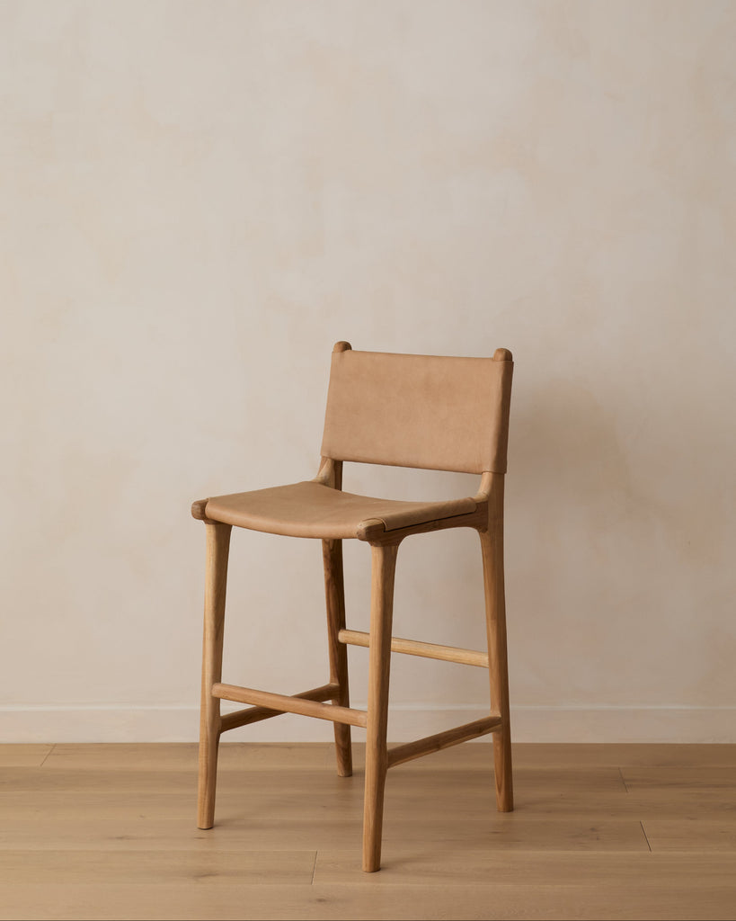 Smooth Leather and Teak Beige Sofia Counter stool against a lime washed wall with white oak floor. Saffron and Poe