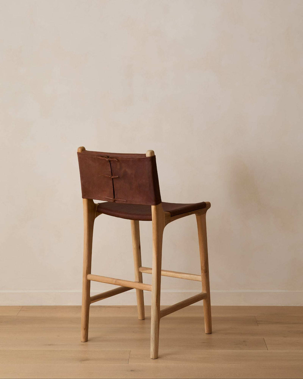 Sofia Counter Stool in saddle leather with Javanese teak wood and leather ties