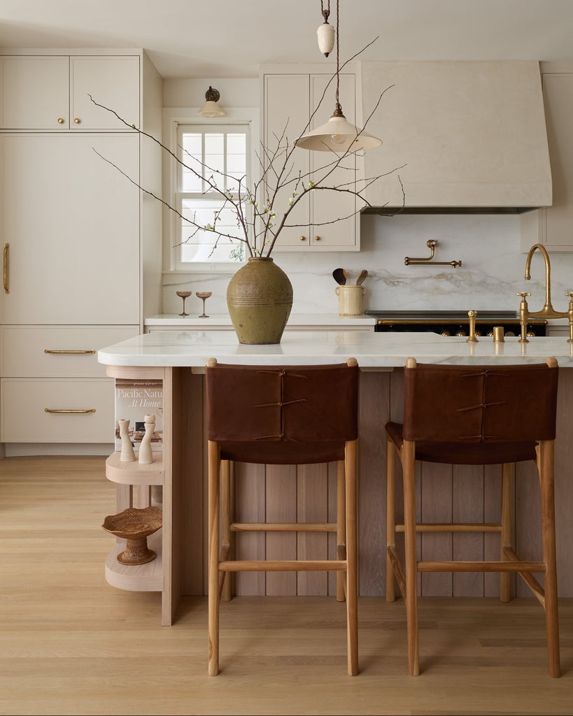 Sofia Counter Stool with saddle leather and back ties in a modern cream and white oak kitchen. Saffron and Poe