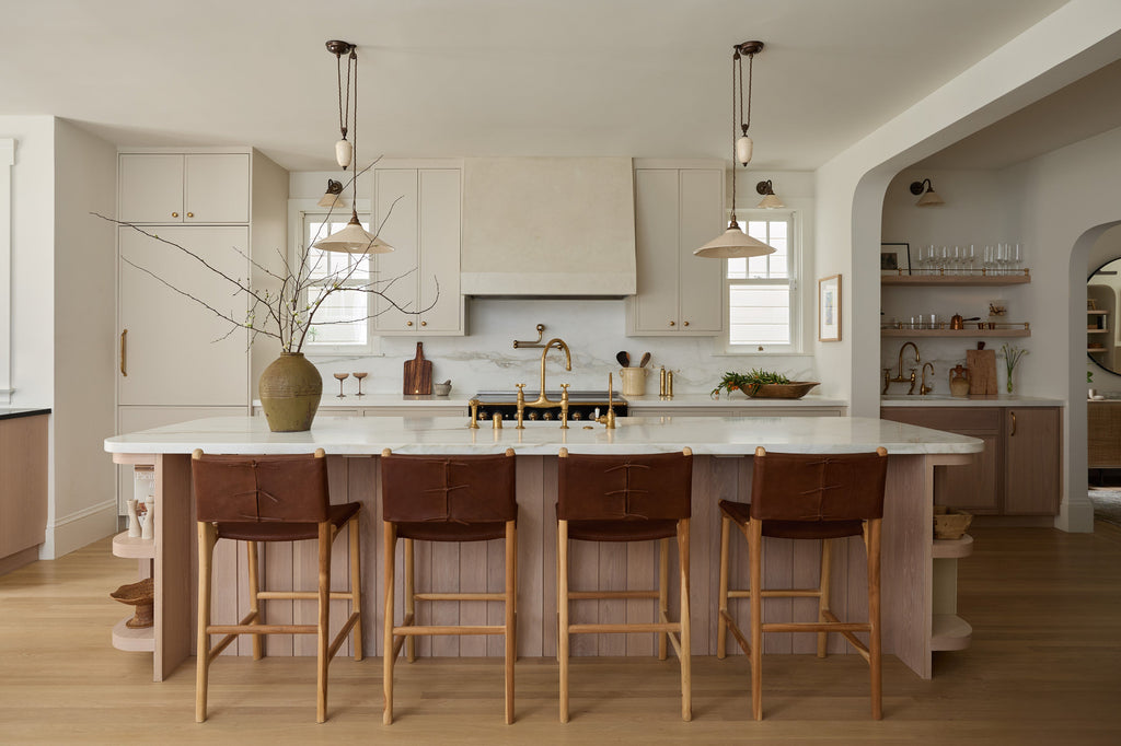 Sofia Counter Stool with saddle leather and back ties in a modern cream and white oak kitchen. Saffron and Poe