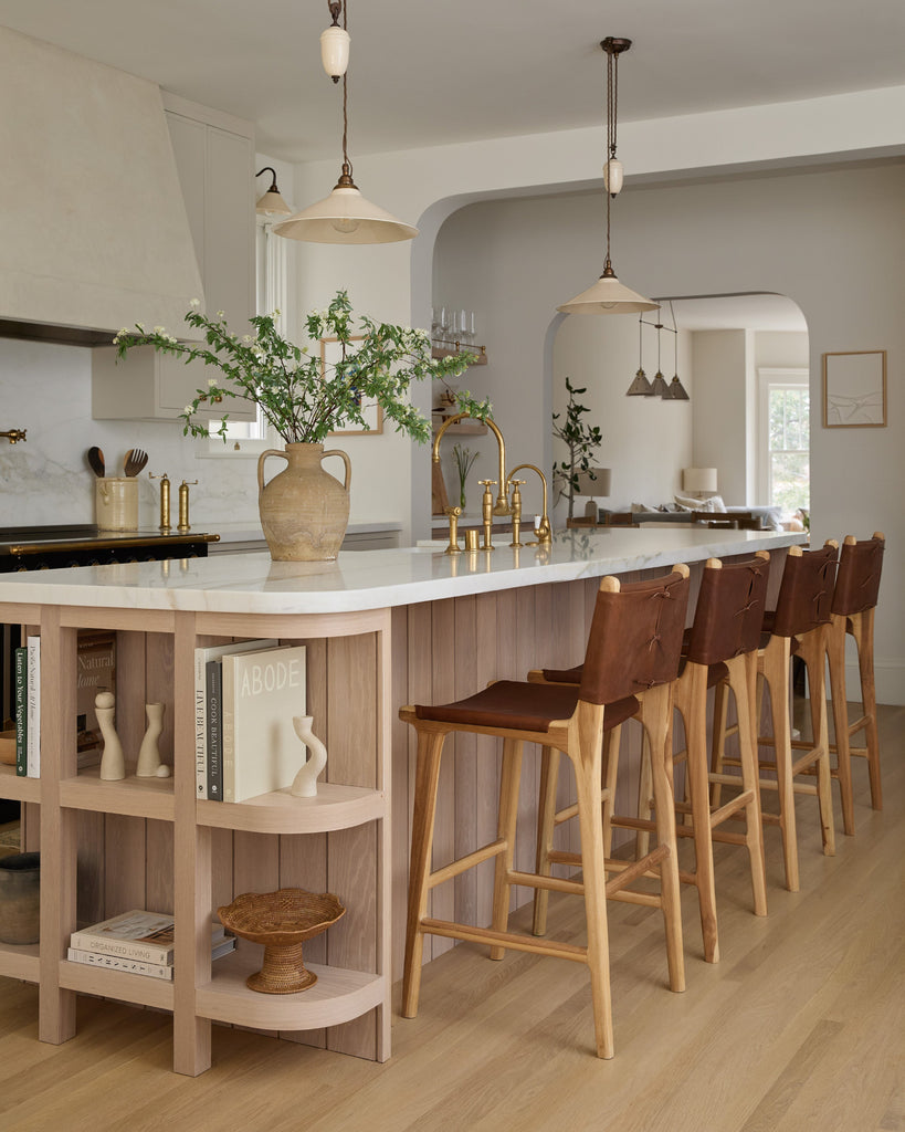 Sofia Counter Stool with saddle leather and back ties in a modern cream and white oak kitchen. Saffron and Poe