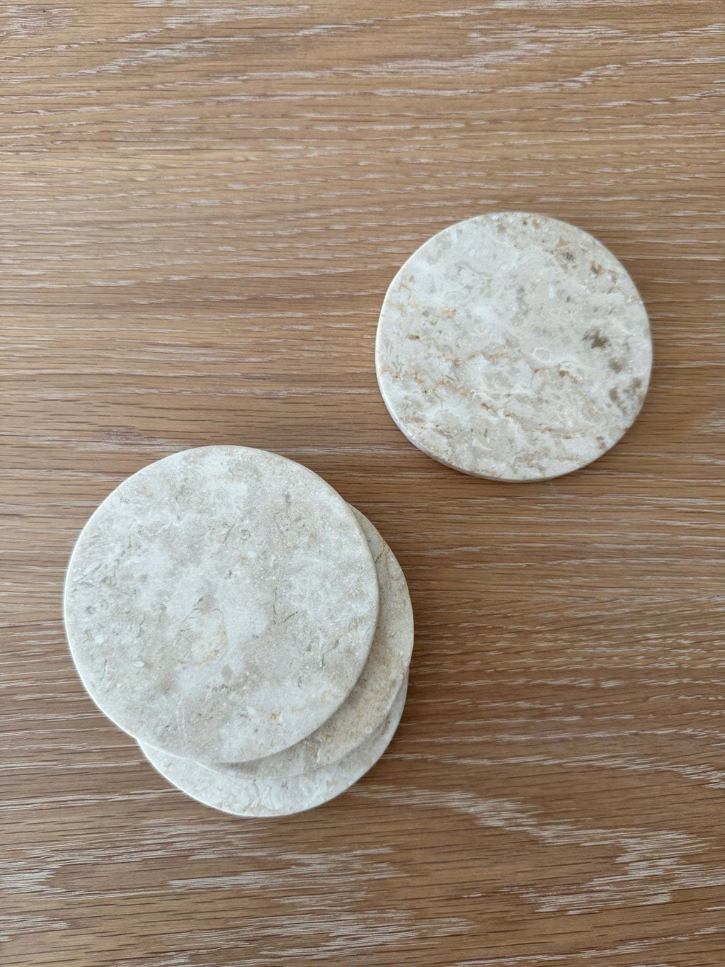 Set of 4 ivory stone coasters with unique marble veining and texture