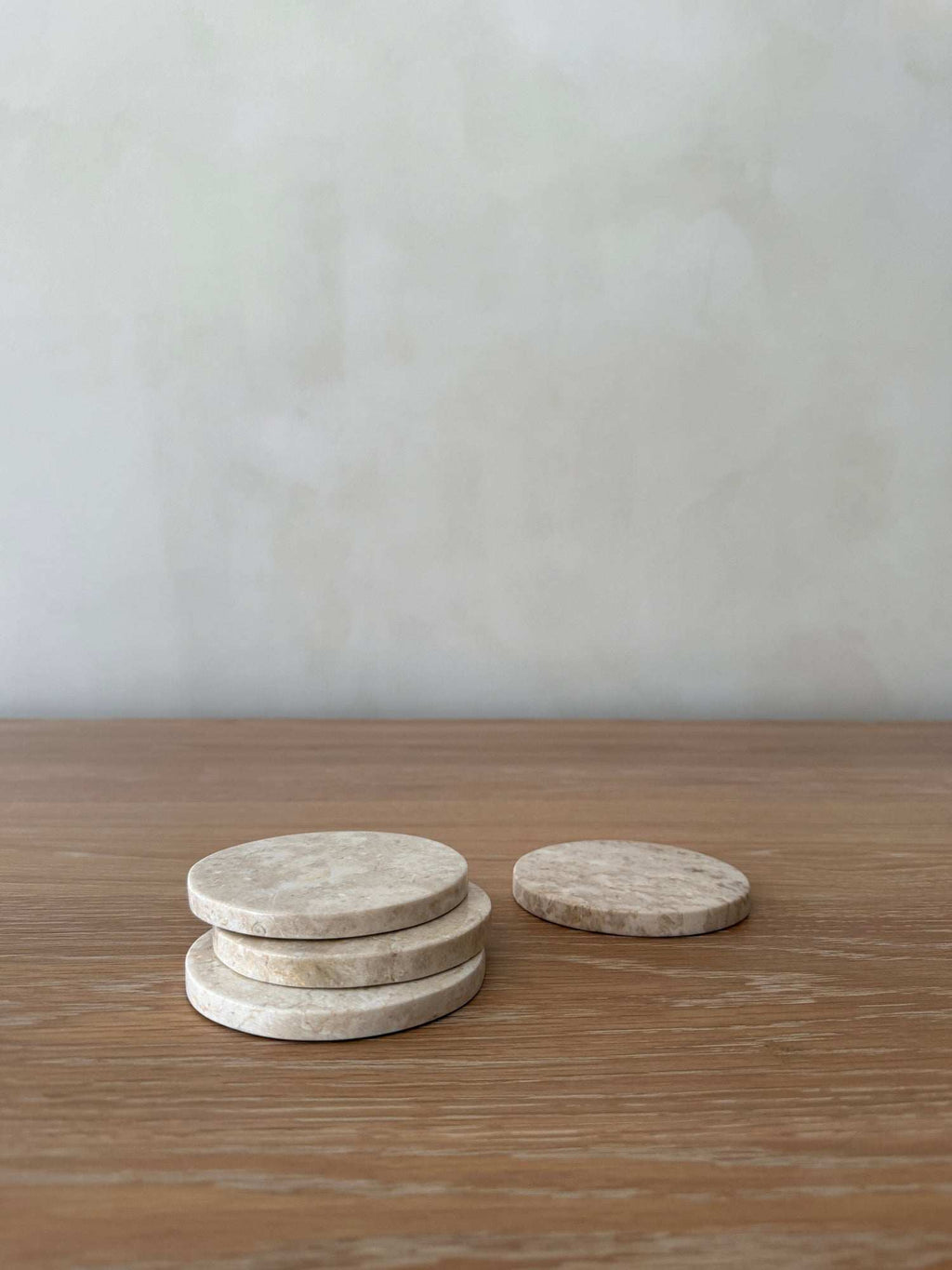 Set of 4 ivory stone coasters with natural marble veining and texture