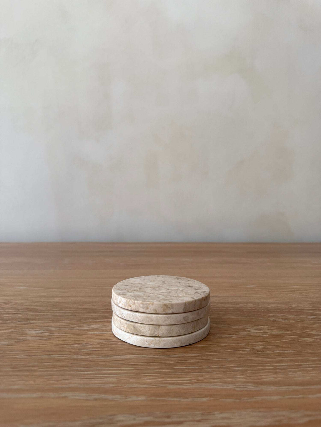 Set of four ivory stone coasters with unique marble veining and texture