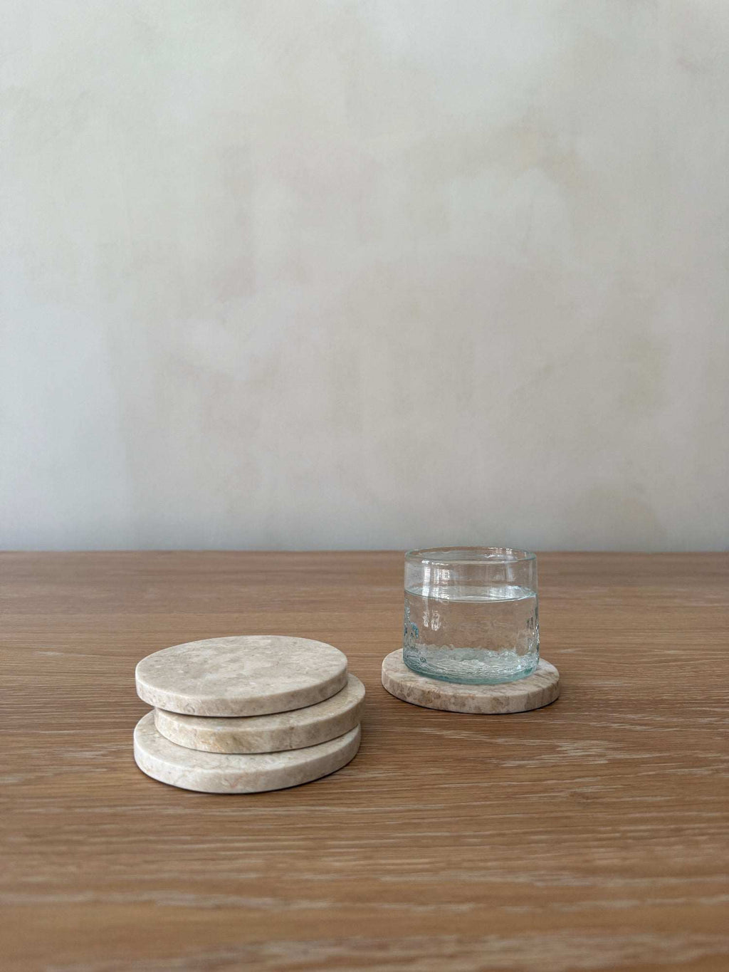 Set of four ivory stone coasters with natural marble veining and texture