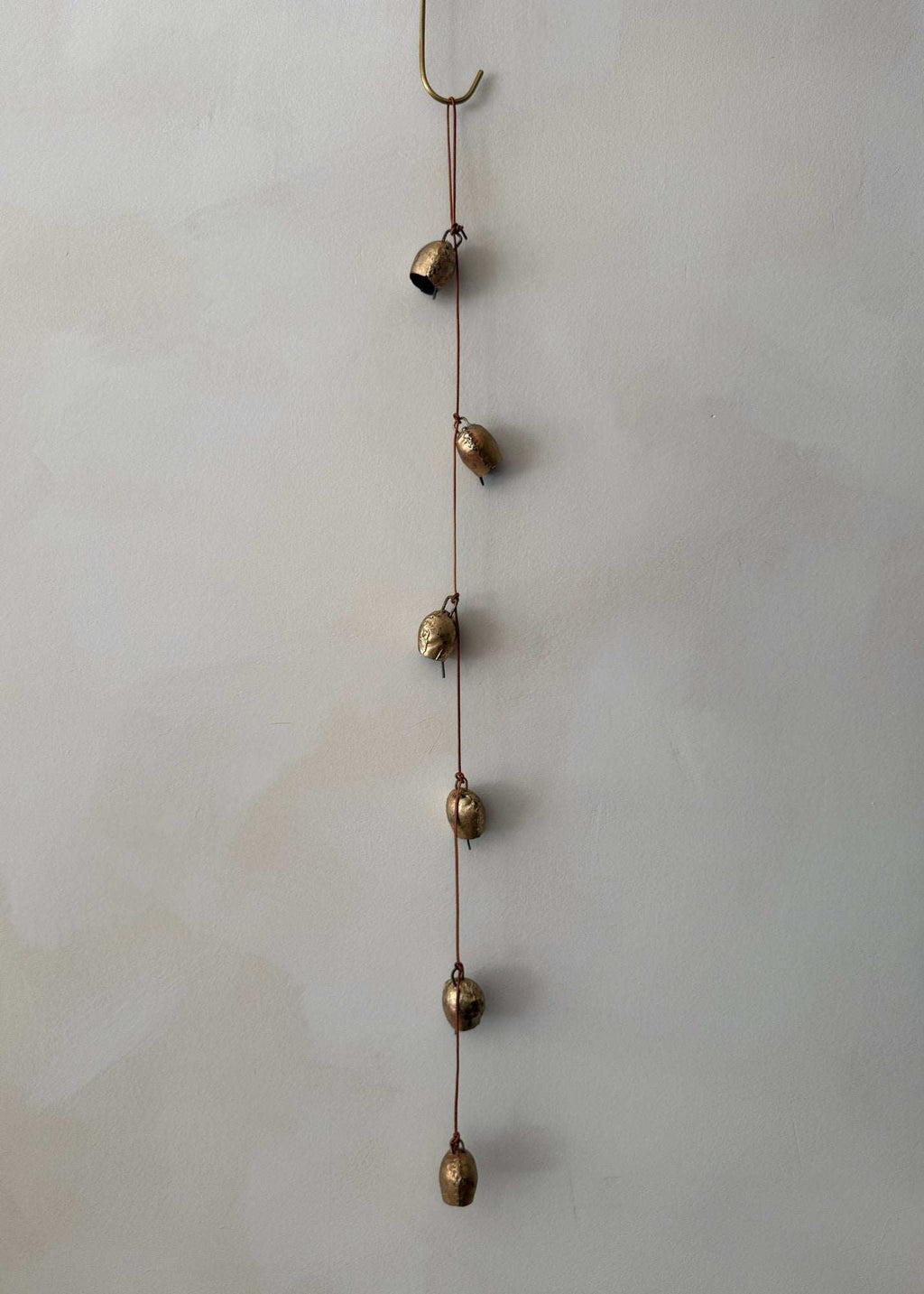 Handcrafted vintage string of bells made from authentic Indian bells on a leather cord for home decor