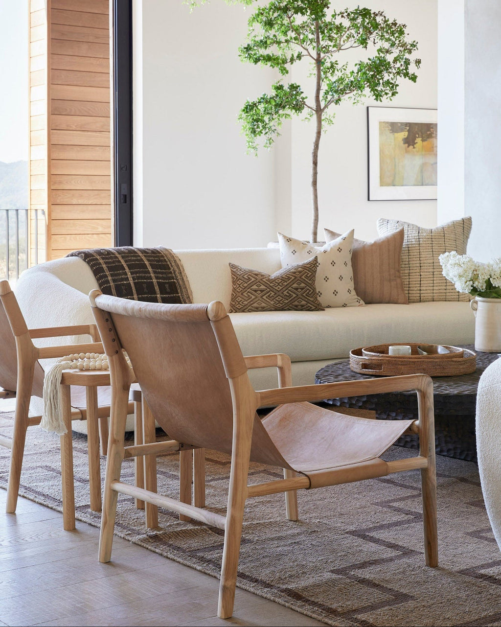 Beige leather sling lounge chair with carved teak frame, handcrafted in Bali, second quality with natural leather variations and scuffs