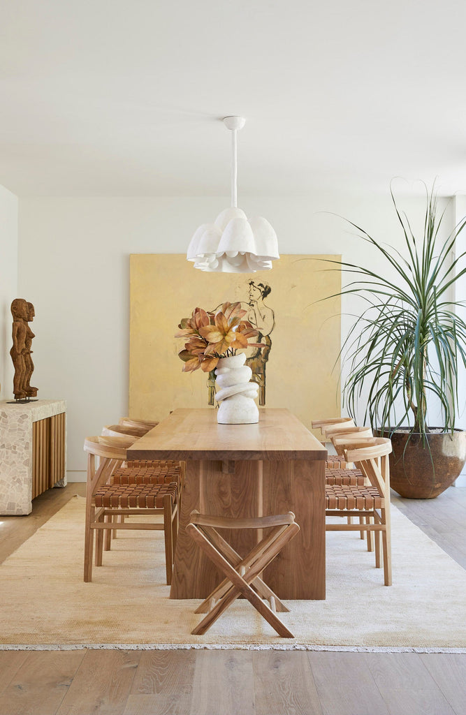 Styled Leather Folding Stool with a custom dining table and curved back woven leather strap dining chairs. - Saffron and Poe