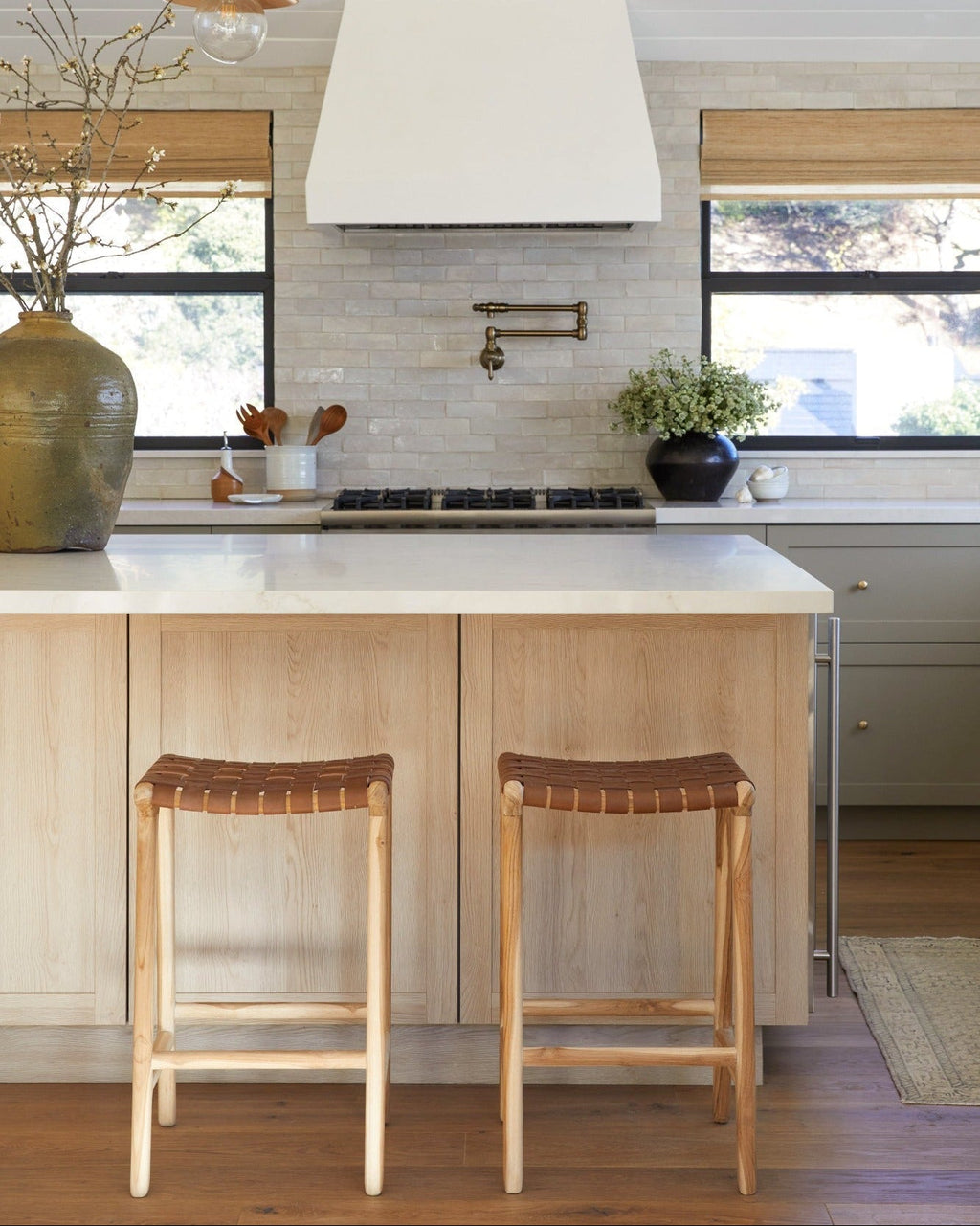 Backless woven leather counter stool in saddle color with carved teak frame and natural matte finish