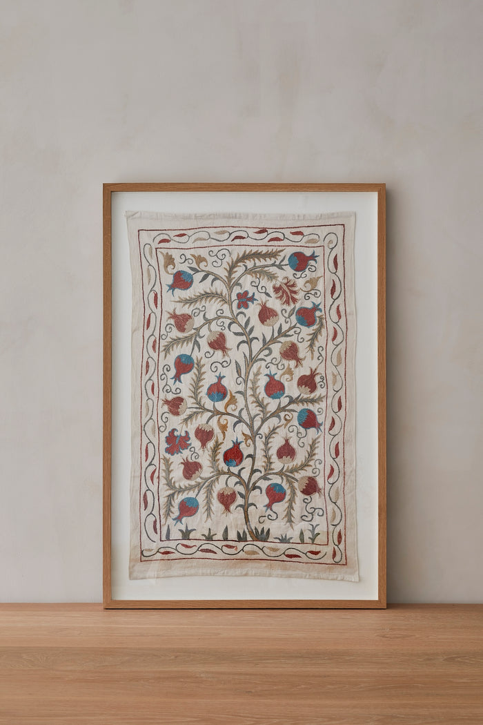 Suzani Textle Pomegranate Framed Hand Embroidered Artwork on a natural beige lime-wash background.