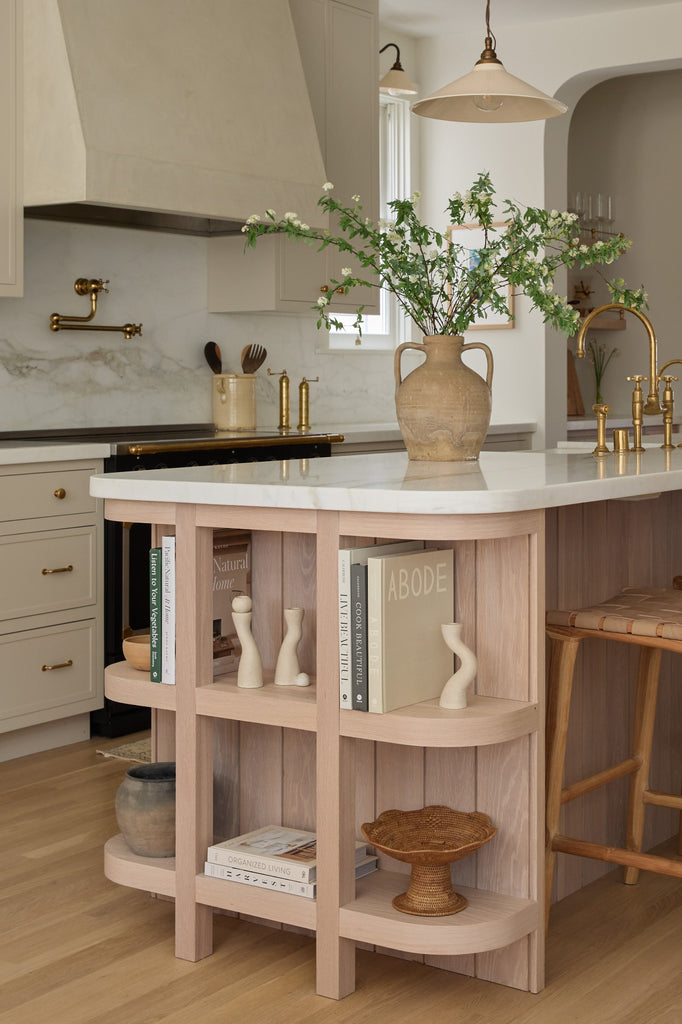 Kitchen island shelving with books and decor items in a timeless kitchen setting. Saffron and Poe.