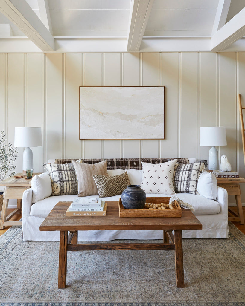Vintage wood coffee table handcrafted from reclaimed dark elm wood with antique Chinese design in bright living room.