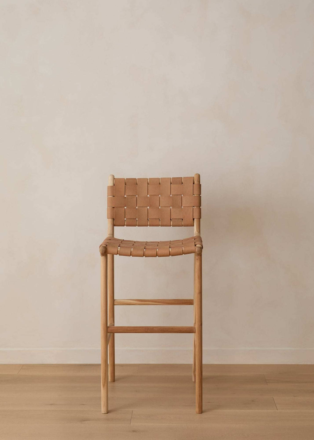 Beige woven leather bar stool with handwoven straps and teak wood frame in natural matte finish