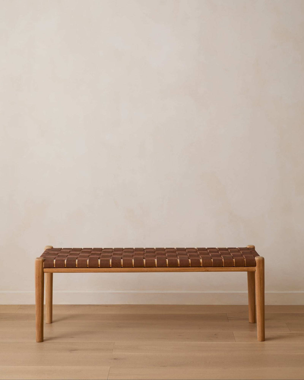 Woven leather bench with saddle-colored straps and teak mid-century frame
