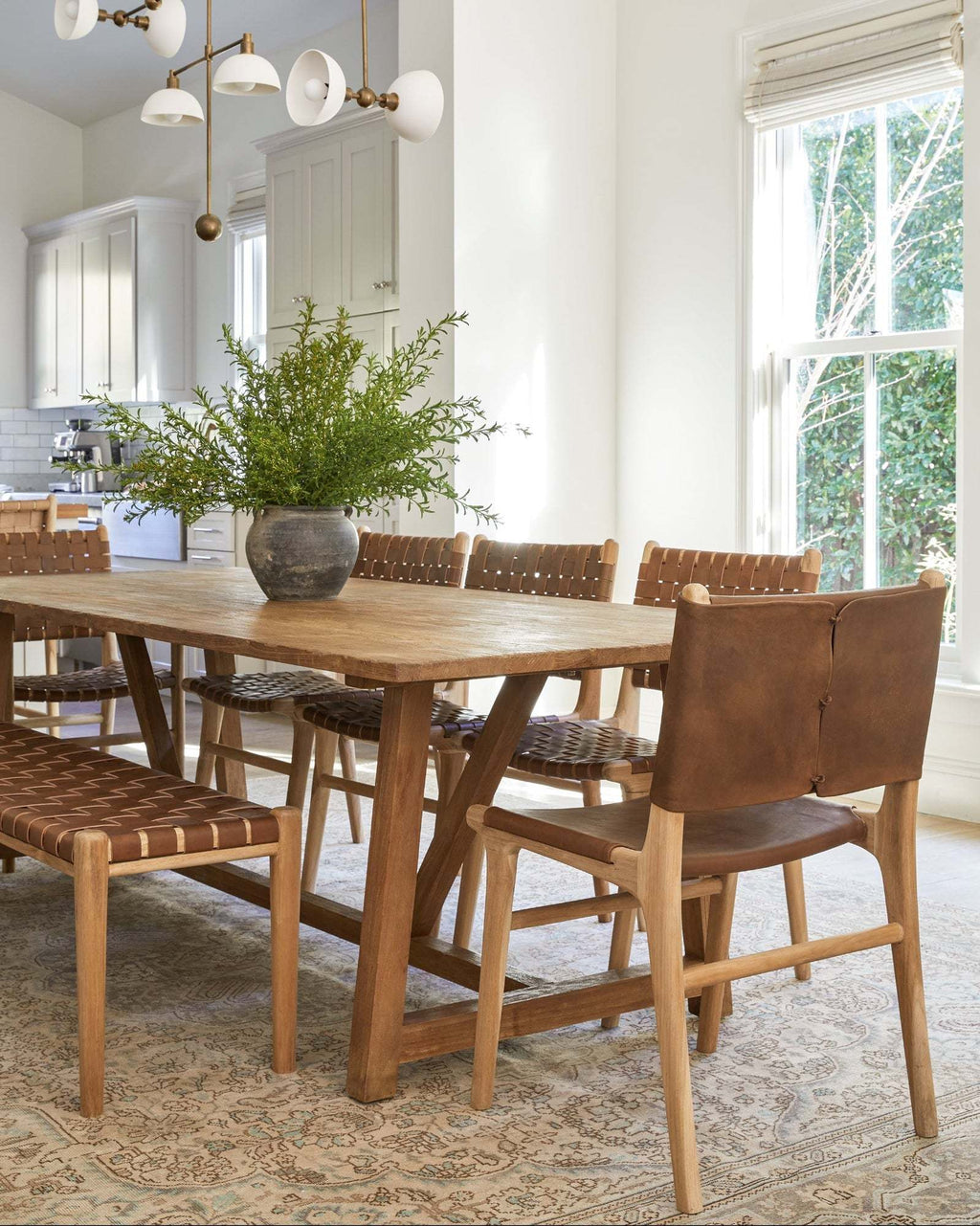 Woven leather bench with saddle-toned leather straps and teak frame in mid-century style in dining room 