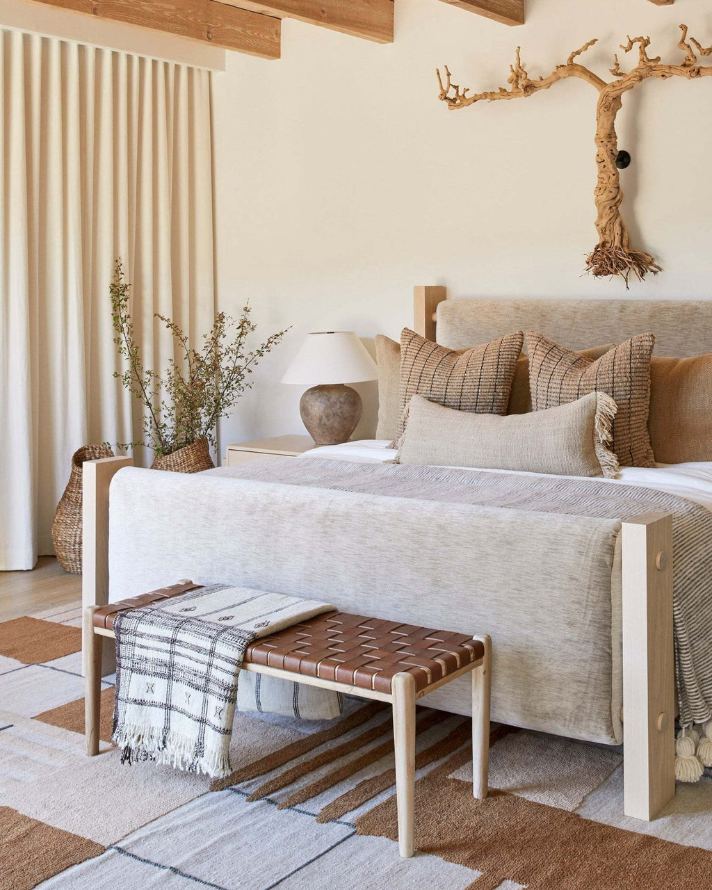 Woven leather bench with teak frame and saddle-colored leather straps showcasing mid-century design in warm bedroom