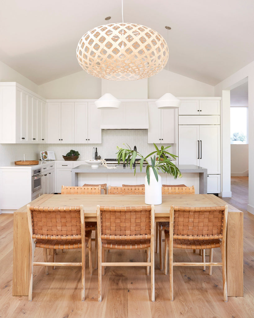 Woven Leather Strap Dining Chair in beige leather styled in a white kitchen.