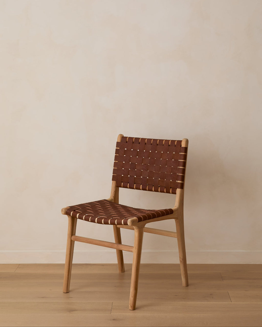 Woven leather dining chair with teak wood frame in saddle color, handcrafted in Bali, second quality with natural leather variations