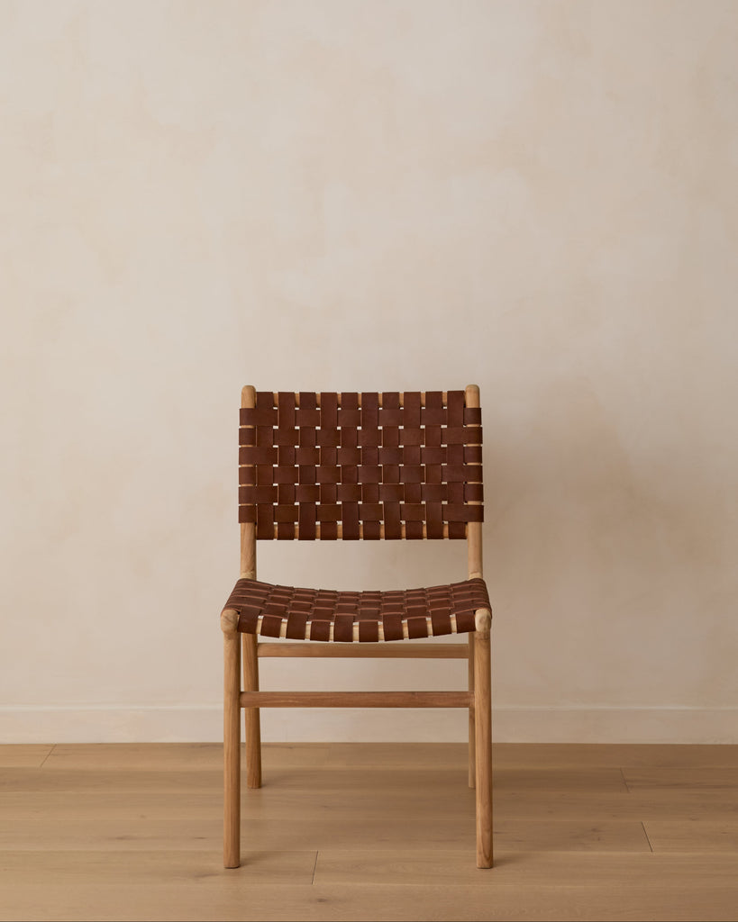 Woven Leather Dining Chair in Saddle against lime washed wall and oak floors. Front view.