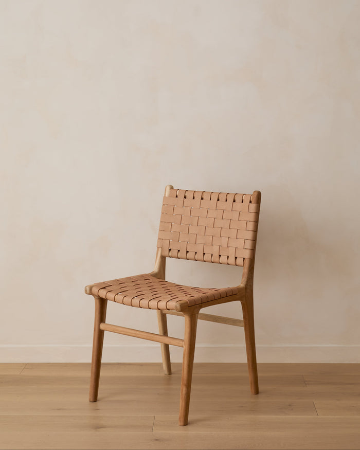 Woven Leather Strap Dining Chair with Beige leather against lime washed wall on oak floor. Front angle