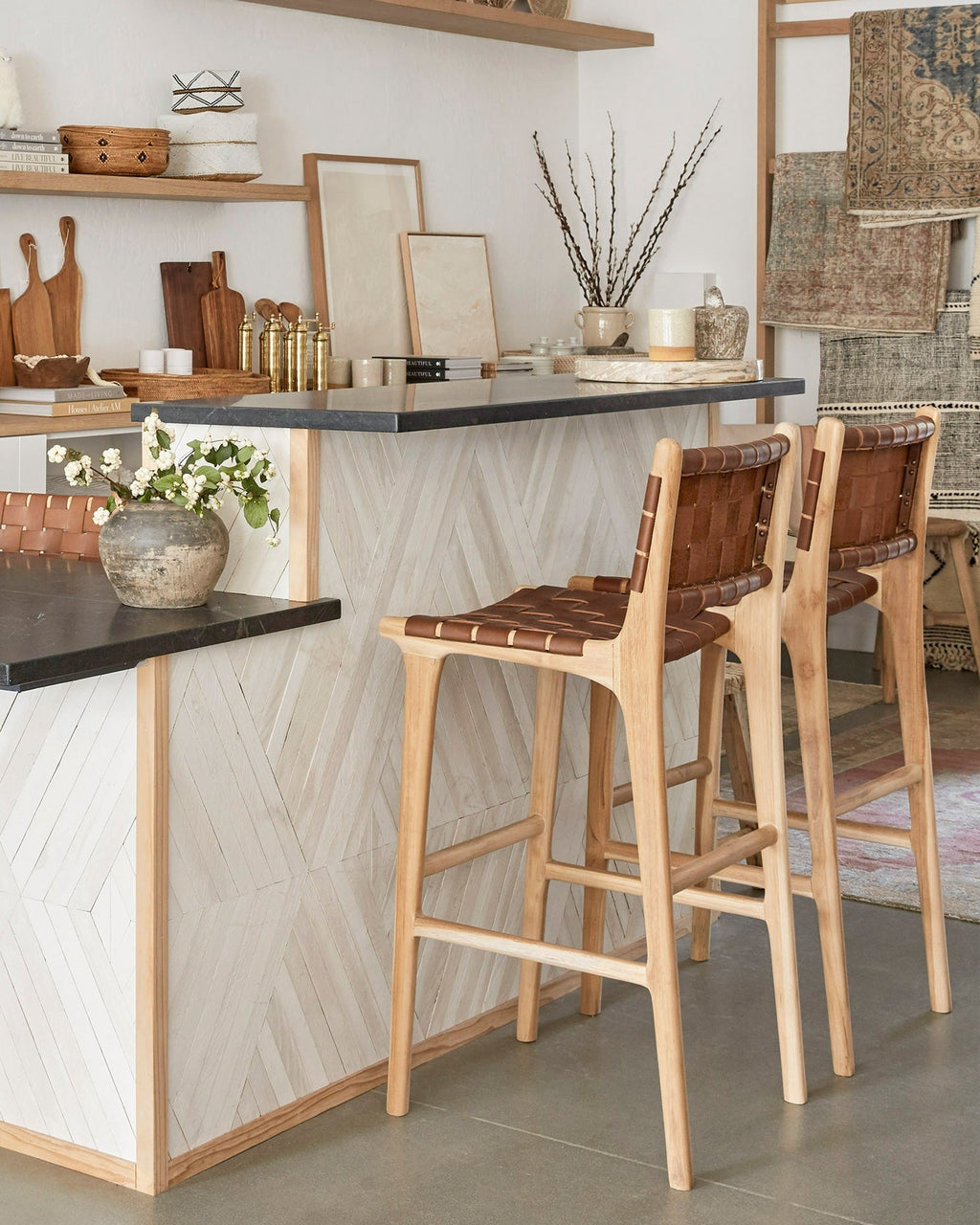 Woven leather bar stool in saddle color with carved teak frame and woven straps