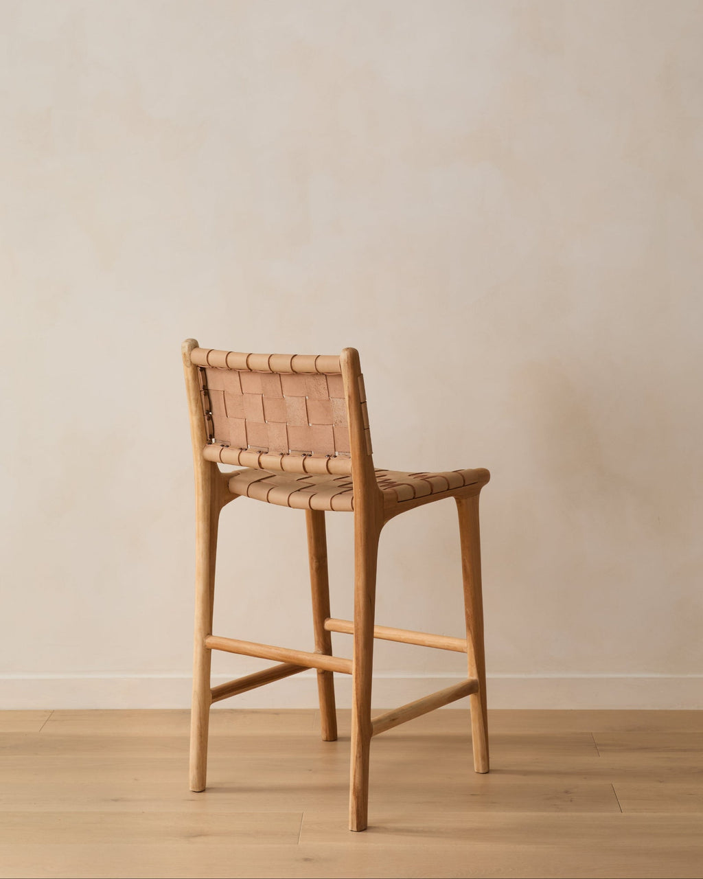 Beige woven leather counter stool with handwoven leather straps and teak wood frame, second quality piece with natural texture and artisanal craftsmanship