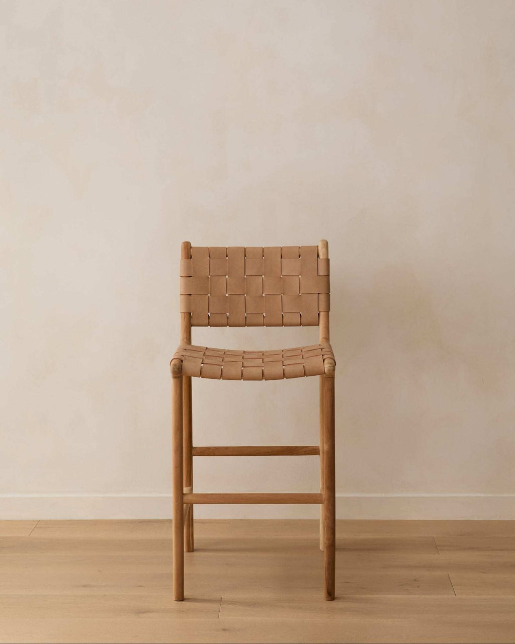 Beige woven leather counter stool with handwoven straps and teak wood frame