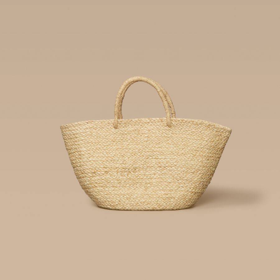 Handwoven braided raffia tote bag in natural color with sturdy handles, lightweight and unlined interior, perfect for everyday use