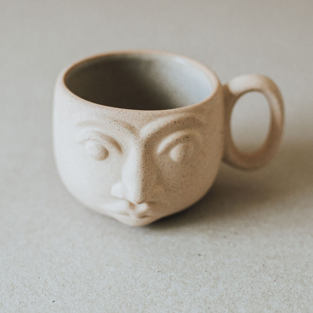 Handcrafted face mug made from high temperature ceramic and local clay with natural earth tones and textured finish