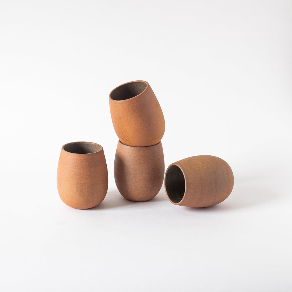 Handcrafted Bola Cup ceramic glass with natural earth tone variations and glazed interior