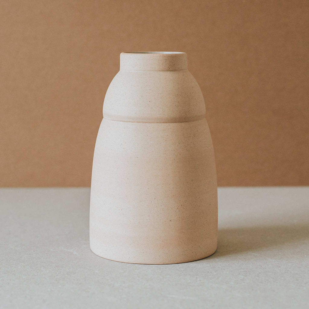 Handcrafted chubby ceramic vase with natural unglazed exterior and earthy tones from local clays