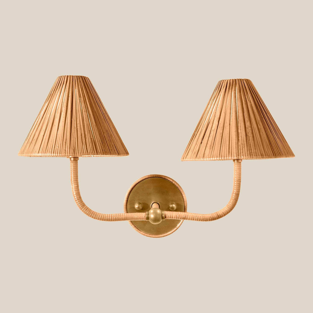 Delphine Double Sconce with two pleated tan rattan shades, wrapped curved arms, and warm brass wall plate and fittings