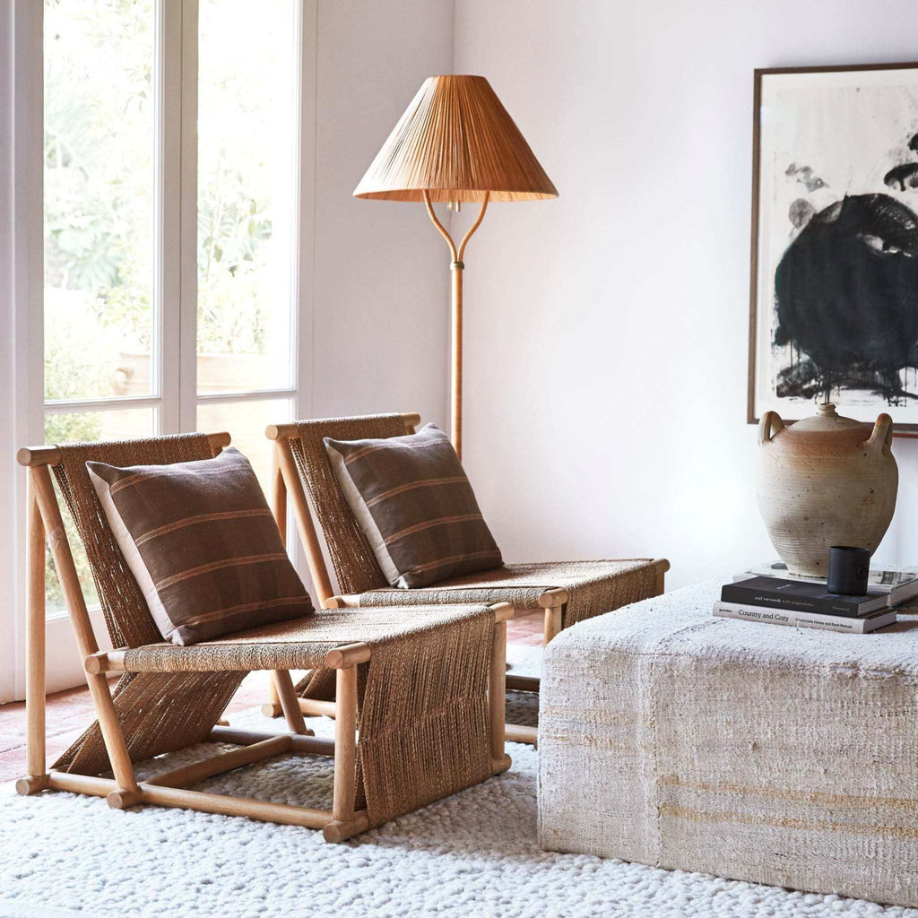 Delphine Floor Lamp with a slender rattan-wrapped frame, warm brown woven shade and brass accents