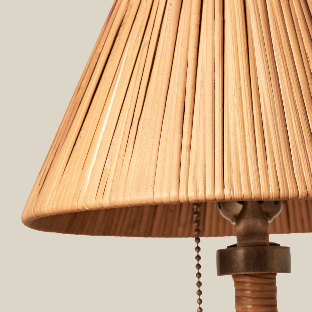 Delphine Mini Table Lamp with a warm natural rattan shade, finely ribbed texture, and dark brass-toned pull chain and fittings