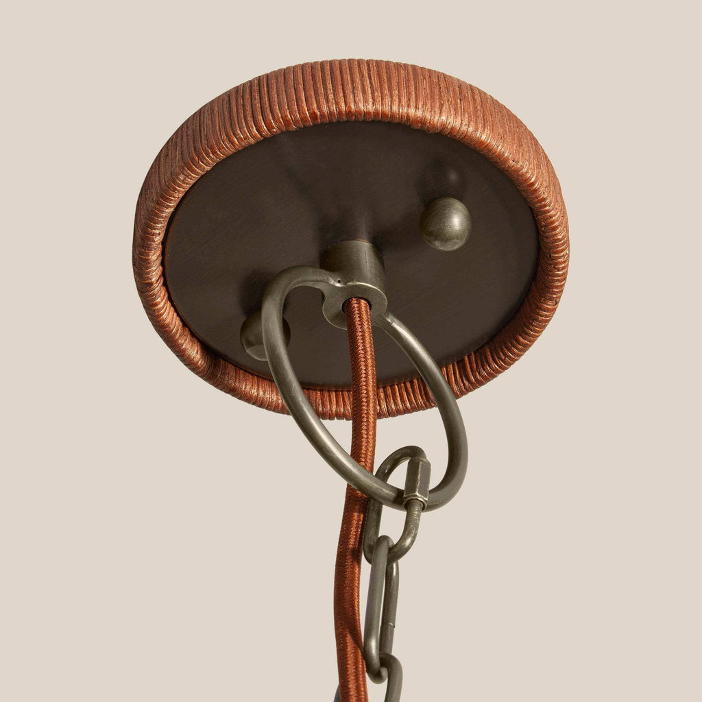 Delphine Wicker Chandelier ceiling canopy with reddish-brown woven wicker trim, dark metal plate, and hanging chain