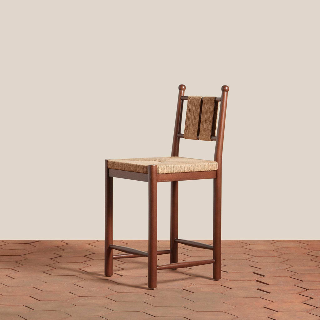 Estela Counter Stool with warm brown solid wood frame, woven tan rush seat and slatted woven back
