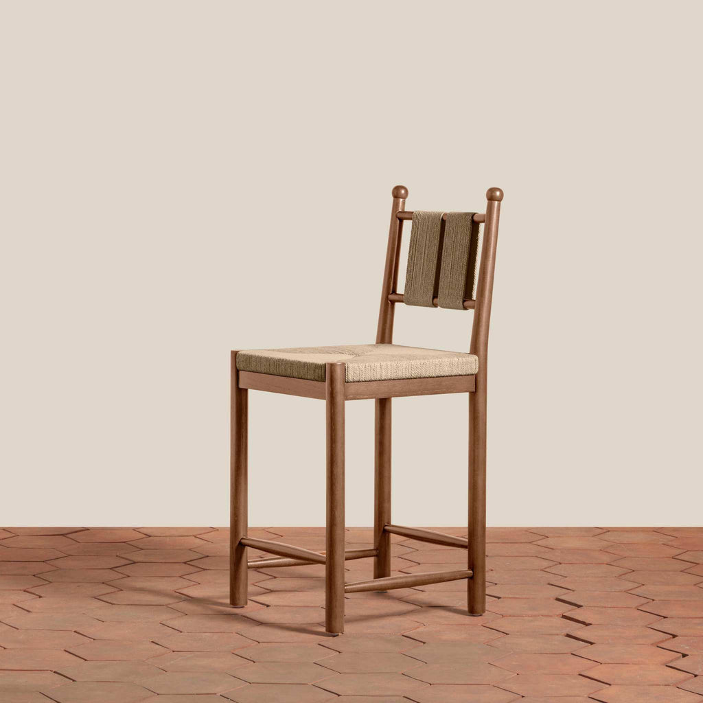 Estela Counter Stool with warm brown solid wood frame, woven beige seat, and dark woven backrest