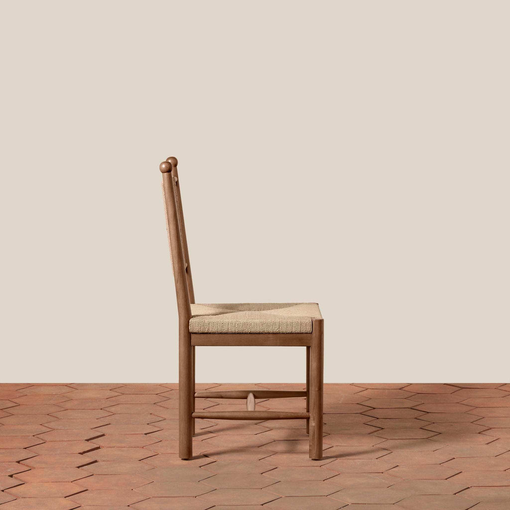 Estela Dining Chair in warm brown wood with a woven beige seat and tall spindle back