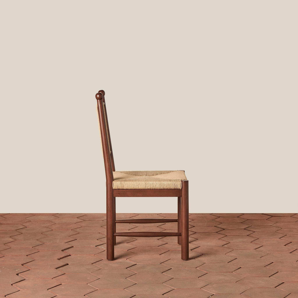 Estela Dining Chair in warm brown wood with a woven rush seat and tall spindle back