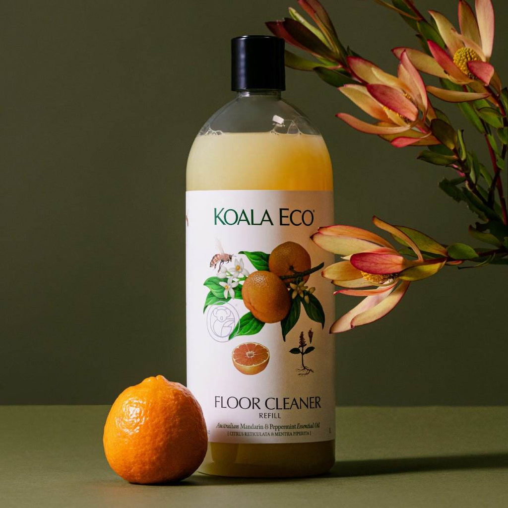 Floor Cleaner - Mandarin + Peppermint in an amber bottle with a black cap, white label and mandarin illustrations