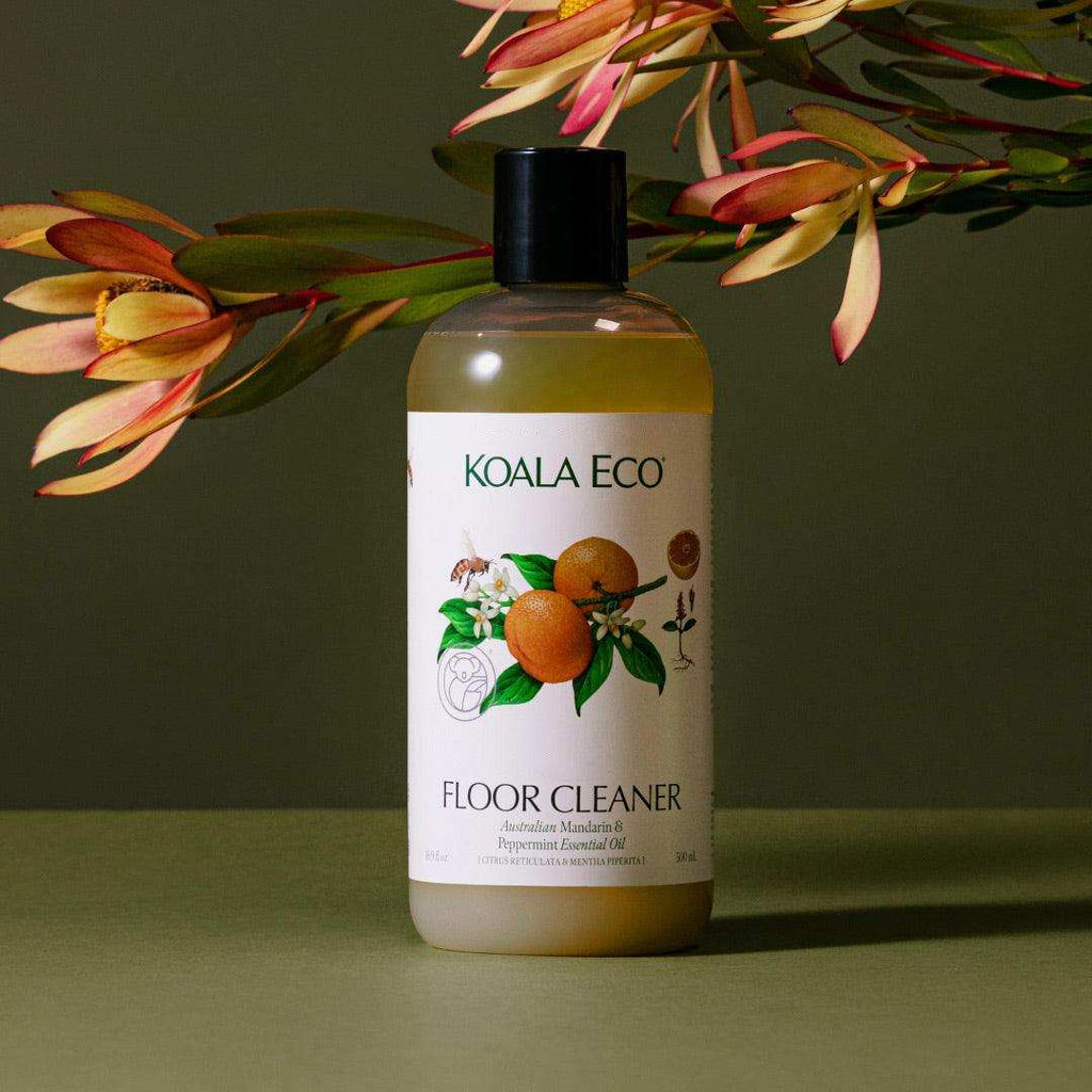 Floor Cleaner - Mandarin + Peppermint in an amber bottle with a black cap and white label featuring orange illustrations