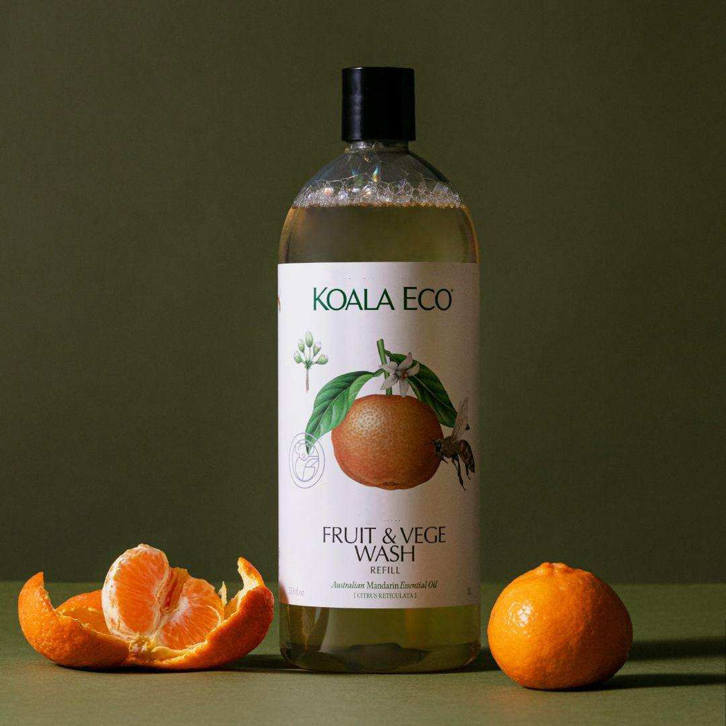 Fruit + Vegetable Wash in a clear bottle with a black cap and white citrus-illustrated label, shown with mandarins