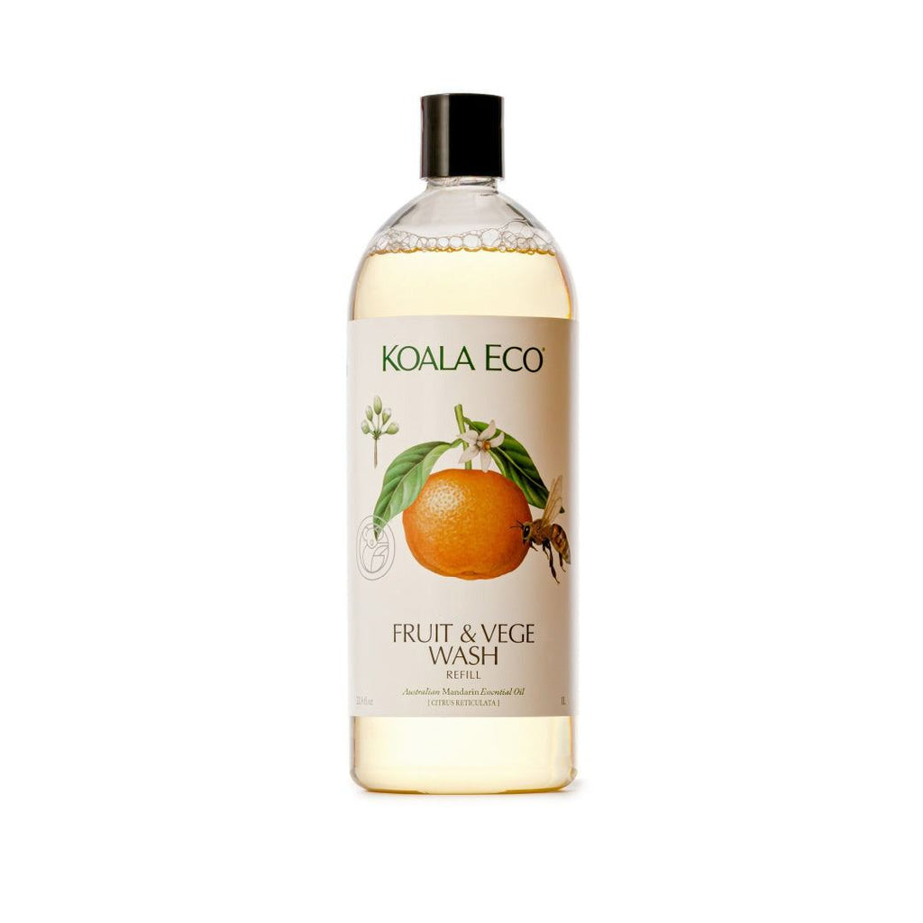 Fruit + Vegetable Wash in a clear bottle with pale yellow liquid, black cap, and cream label featuring an orange