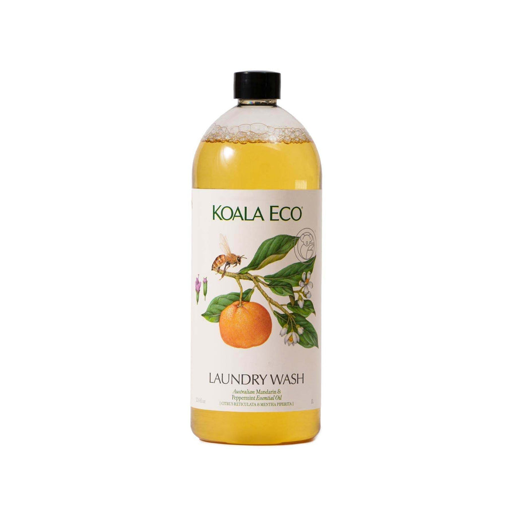 Laundry wash bottle in clear plastic with golden liquid and a botanical label featuring orange fruit and green leaves, Koala Eco's Mandarin