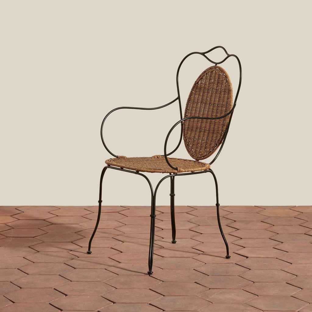 Lacoste Indoor/Outdoor Wicker Arm Chair with brown woven rattan seat and backrest, black wrought iron frame with curved armrests