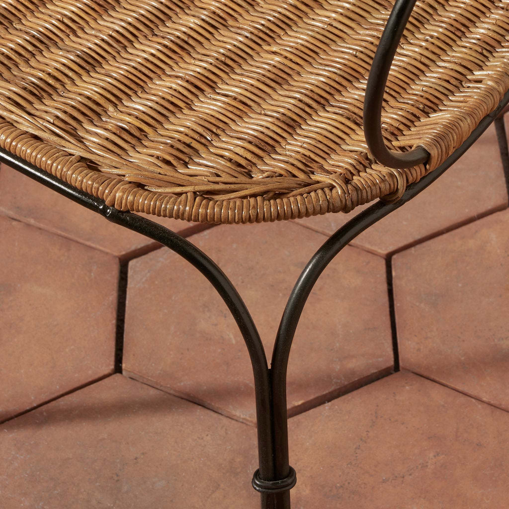 Lacoste Indoor/Outdoor Wicker Arm Chair featuring natural brown rattan wicker seat with black wrought iron frame and leg details